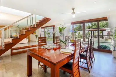 a dining room with a wooden table and chairs at Villa Lilja in Seminyak