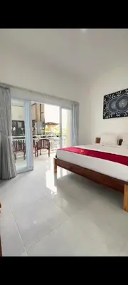a bedroom with a large bed and a large window at narayuka house in Seminyak