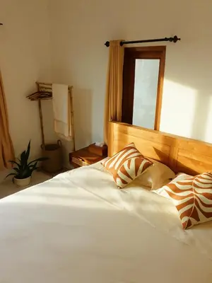 a bedroom with a large white bed with a mirror at Vee Surf in Canggu