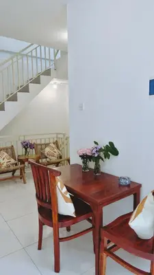 a room with a table and chairs and a staircase at Vee Surf in Canggu