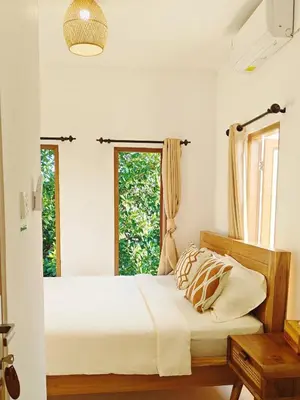 a bedroom with a bed and two windows at Vee Surf in Canggu