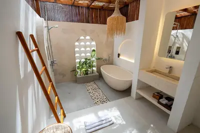 a bathroom with a tub and a toilet and a sink at Sueño Villa Seminyak in Seminyak