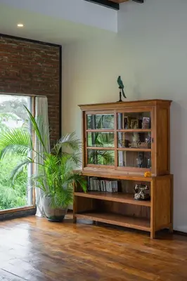 a wooden book shelf in a room with a plant at Villa Jannu by DreamAwayBali in Seminyak