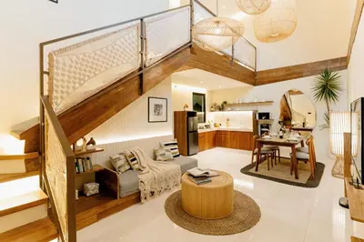 a living room with a staircase and a kitchen at Balimac Villa 3 in Seminyak