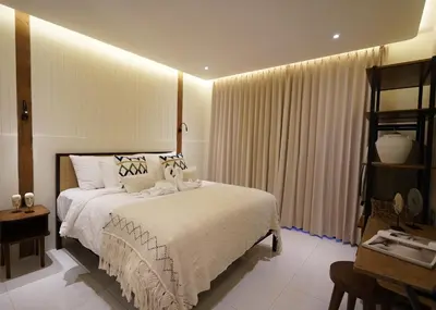 a bedroom with a bed with white sheets and curtains at Balimac Villa 3 in Seminyak