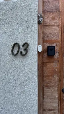 a wooden door with a number on a wall at Balimac Villa 3 in Seminyak
