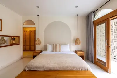 a bedroom with a large bed and a window at Wayang Villa by Betterplace in Kerobokan