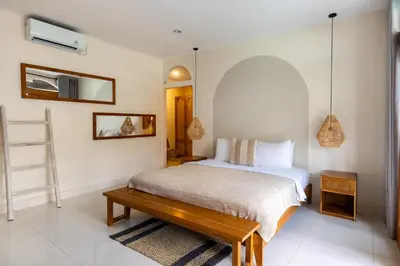 a bedroom with a bed and a wooden table at Wayang Villa by Betterplace in Kerobokan