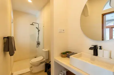 a white bathroom with a sink and a mirror at Wayang Villa by Betterplace in Kerobokan