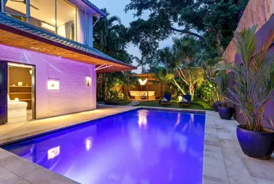 a swimming pool in front of a house at Villa Julietta, 4 BR in the heart of Seminyak in Seminyak