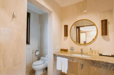 a bathroom with a toilet and a sink and a mirror at Villa Anggrek Jimbaran in Jimbaran