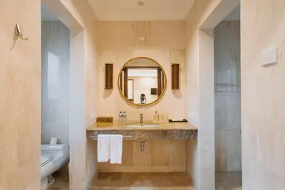 a bathroom with a sink and a mirror and a toilet at Villa Anggrek Jimbaran in Jimbaran