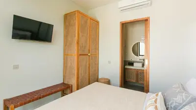 a bedroom with a bed and a tv and a mirror at Sunset D1 Villa by Betterplace in Kerobokan