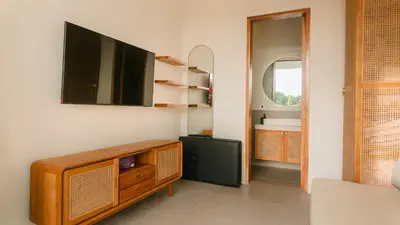 a living room with a tv on a wall at Sunset D1 Villa by Betterplace in Kerobokan