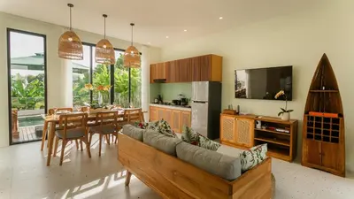 a living room with a couch and a dining room at Sunset D1 Villa by Betterplace in Kerobokan