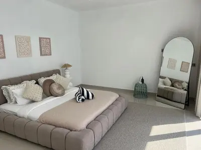 a bedroom with a large bed and a mirror at Nomadic LUX villa in Canggu