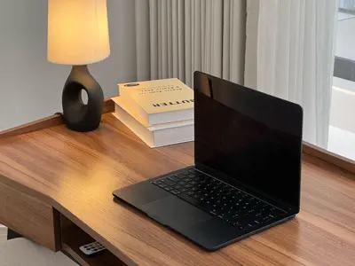 a laptop computer sitting on top of a wooden desk at Nomadic LUX villa in Canggu