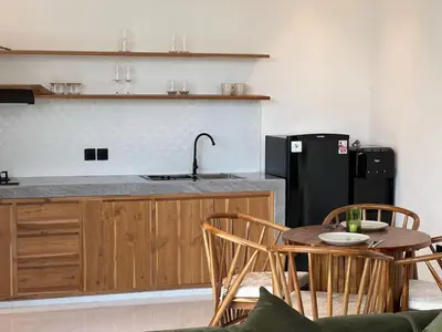 a kitchen with a table and chairs and a sink at LUX Villa, Private Pool Berawa in Canggu