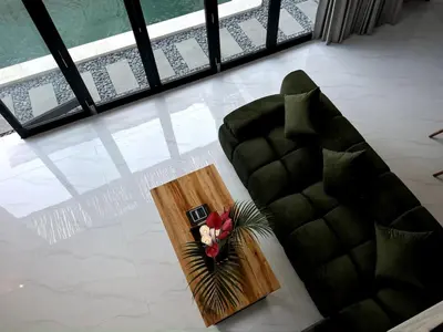 a living room with a couch and a table with flowers on it at LUX Villa, Private Pool Berawa in Canggu