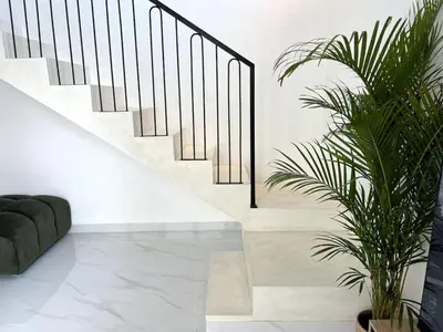 a staircase with black railings in a living room at LUX Villa, Private Pool Berawa in Canggu