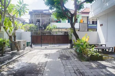 a courtyard with a wooden gate in a house at Mantra Guesthouse in Denpasar