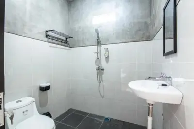a white bathroom with a sink and a toilet at Mantra Guesthouse in Denpasar