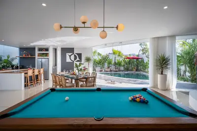 a living room with a pool table and a kitchen at Villa Soluna Luxury 4BD Villa with Pool & Zen Vibes in Seminyak
