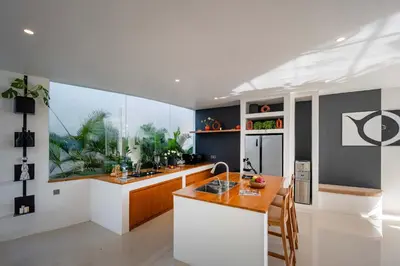 a kitchen with a large window and a kitchen with a counter at Villa Soluna Luxury 4BD Villa with Pool & Zen Vibes in Seminyak