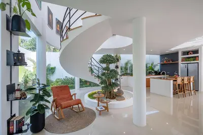 a kitchen and living room with a spiral staircase at Villa Soluna Luxury 4BD Villa with Pool & Zen Vibes in Seminyak