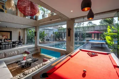 an indoor pool with a pool table in a house at Artistic 4BD Villa with Private Pool & Jungle Vibes in Seminyak