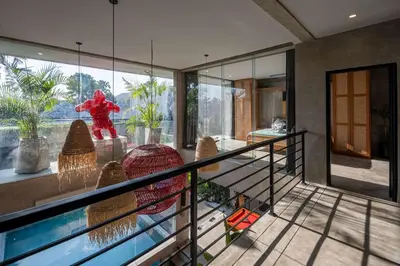a house with a glass balcony with a statue in it at Artistic 4BD Villa with Private Pool & Jungle Vibes in Seminyak