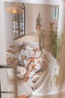 a group of people sitting on a couch in a living room at Luxury 4BD Villa Casa Diplomatico with Private Pool in Seminyak