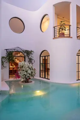 a swimming pool in a house with windows at Luxury 4BD Villa Casa Diplomatico with Private Pool in Seminyak