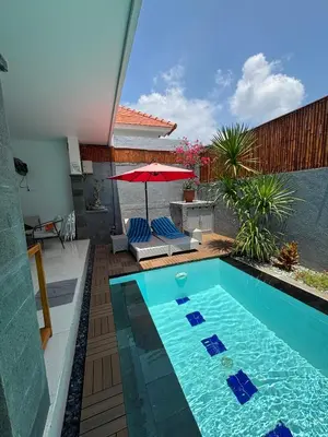 a swimming pool in a backyard with an umbrella at Private Villa Fabian - Lap pool - Seminyak in Seminyak