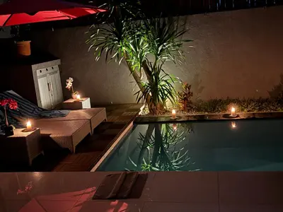 a backyard with a pool with candles and plants at Private Villa Fabian - Lap pool - Seminyak in Seminyak