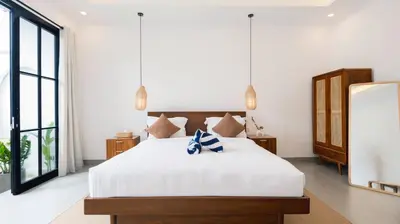 a bedroom with a large white bed and a large window at Kamila Villa 2 by Villa Finder in Seminyak