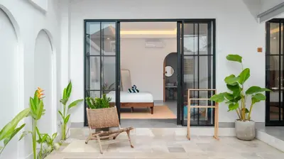 a room with plants and a room with a bed at Kamila Villa 2 by Villa Finder in Seminyak
