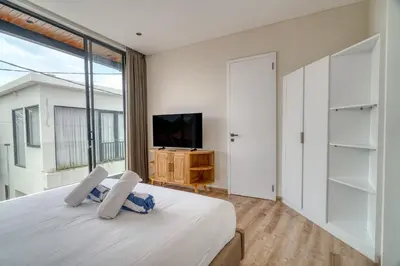 a bedroom with a large bed and a television at Nirvana Villa 3BR Brand New in Umalas, Canggu in Kerobokan