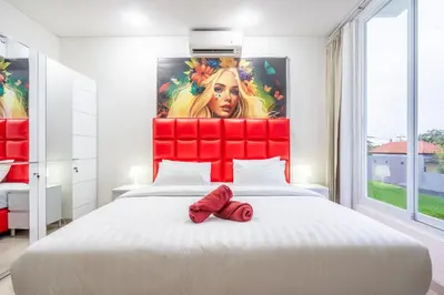 a bedroom with a large bed with a red headboard at Brand new luxury minimalistic villa The Toy with 3 bedrooms in Kerobokan