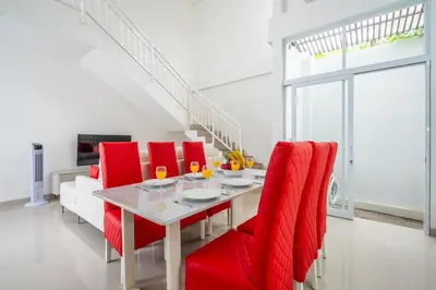 a dining room with a table and red chairs at Brand new luxury minimalistic villa The Toy with 3 bedrooms in Kerobokan