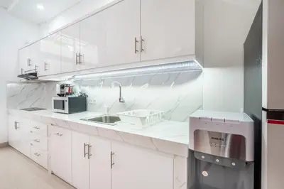 a white kitchen with a sink and a microwave at Brand new luxury minimalistic villa The Toy with 3 bedrooms in Kerobokan