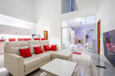 a living room with a white couch and red pillows at Brand new luxury minimalistic villa The Toy with 3 bedrooms in Kerobokan