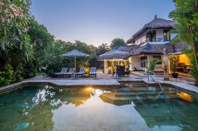 a backyard with a pool and a house at Villa Nyumpene in Legian in Legian