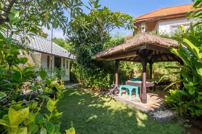 a gazebo with a table and a bench in a garden at Villa Nyumpene in Legian in Legian