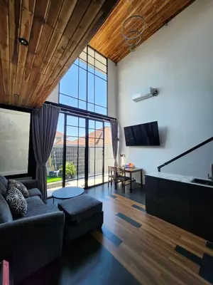 a living room with a couch and a large window at Felly House in Kerobokan