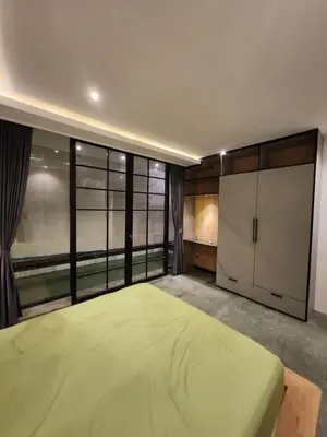 a bedroom with a large bed and a large window at Felly House in Kerobokan