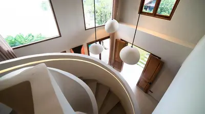 a spiral staircase in a house with white ceilings at Villa Gabrielle in Seminyak