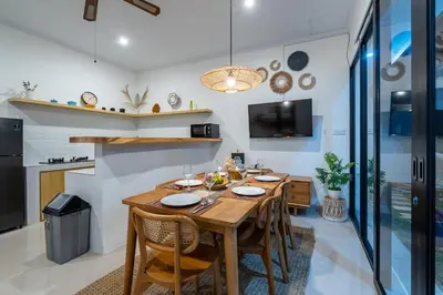 a dining room with a wooden table and chairs at Ageta Villa 3 bedrooms Umalas with pool in Kerobokan