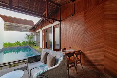 a patio with a couch and a table next to a pool at Cendani Private Pool Villa Bali in Kuta