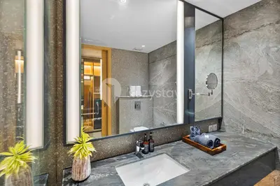 a bathroom with a sink and a large mirror at Moriya by Kozystay - Nusa Dua in Nusa Dua